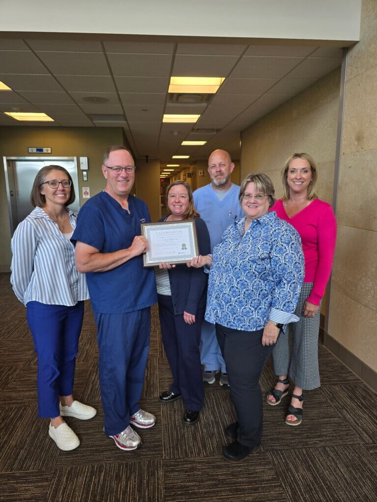 CALS Executive Director Ann Gihl presents the CALS Hospital Award to Riverwood Healthcare Center (Aitkin) staff and leadership.